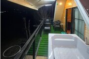 کلبه سوئیسی تکخواب جکوزی دار آیهان در ماسال | نمای تراس پشت کلبه همراه با جکوزی با ویوء مزرعه و جنگل
